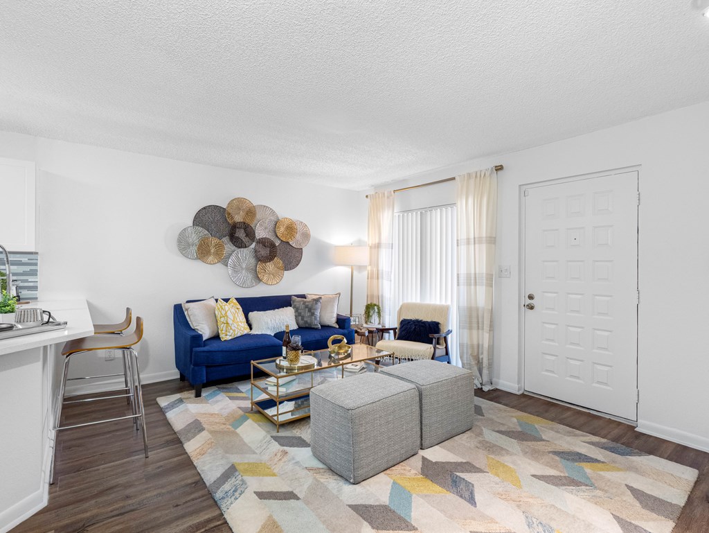 A living room with a blue couch and a wooden coffee table.